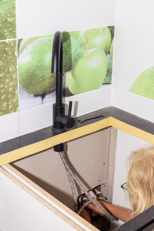 Plumber Working on a Faucet